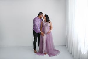 Romantic maternity portrait with couple in purple and lavender attire.