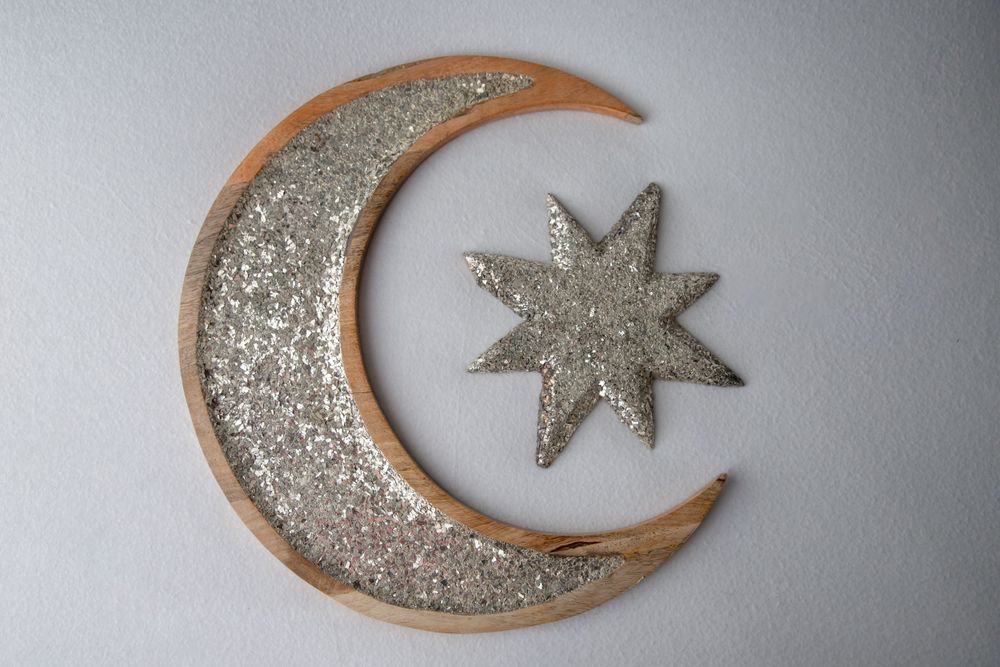 Decorative glitter crescent moon and star wall decor in gold and silver tones.