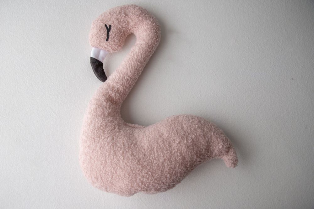Pink fluffy flamingo stuffed animal plush toy with curved neck on white background.