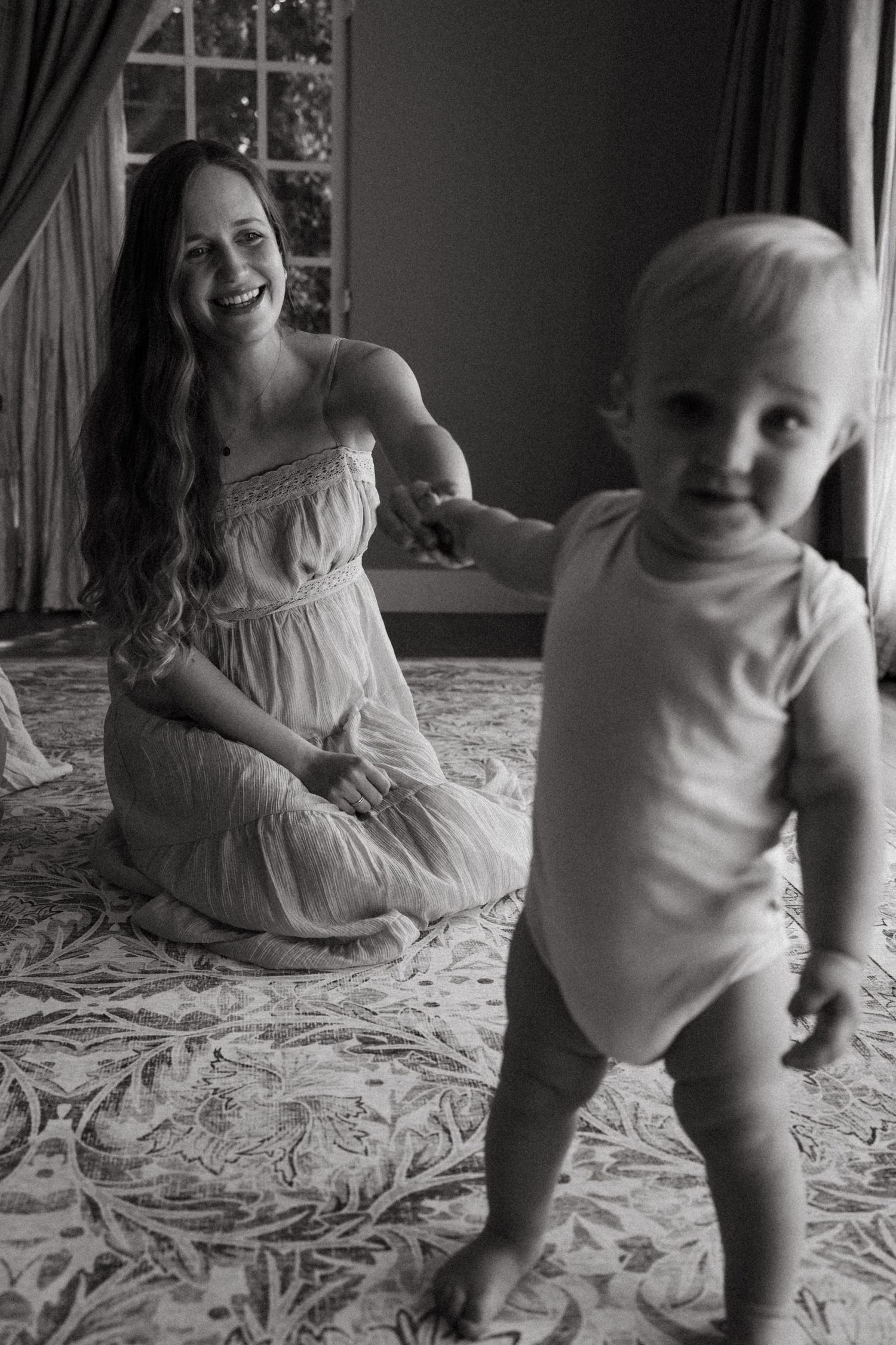 Black and white photographs capturing joyful moments on a textured bedspread.