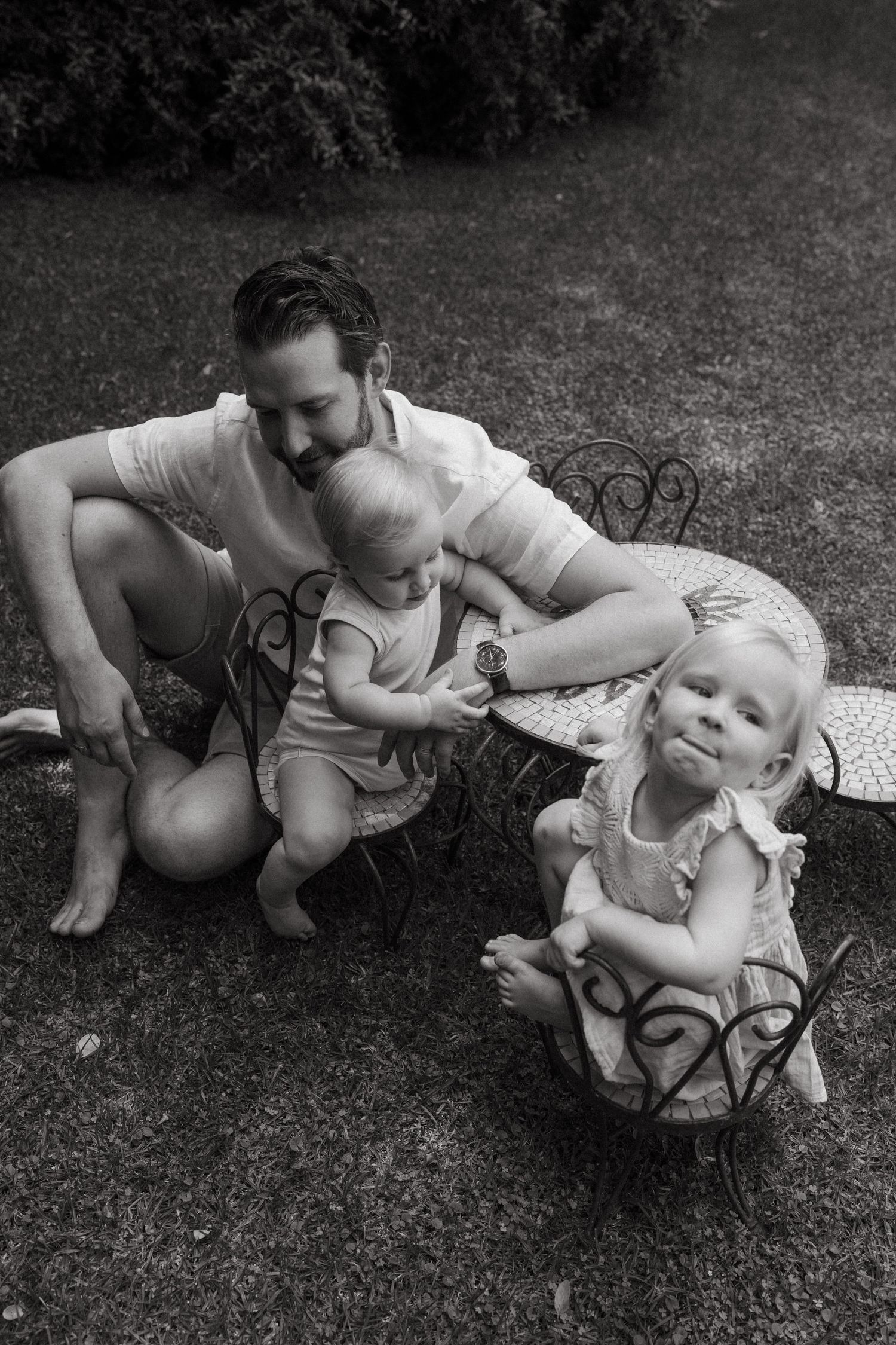 A playful outdoor reading session on the grass in black and white.