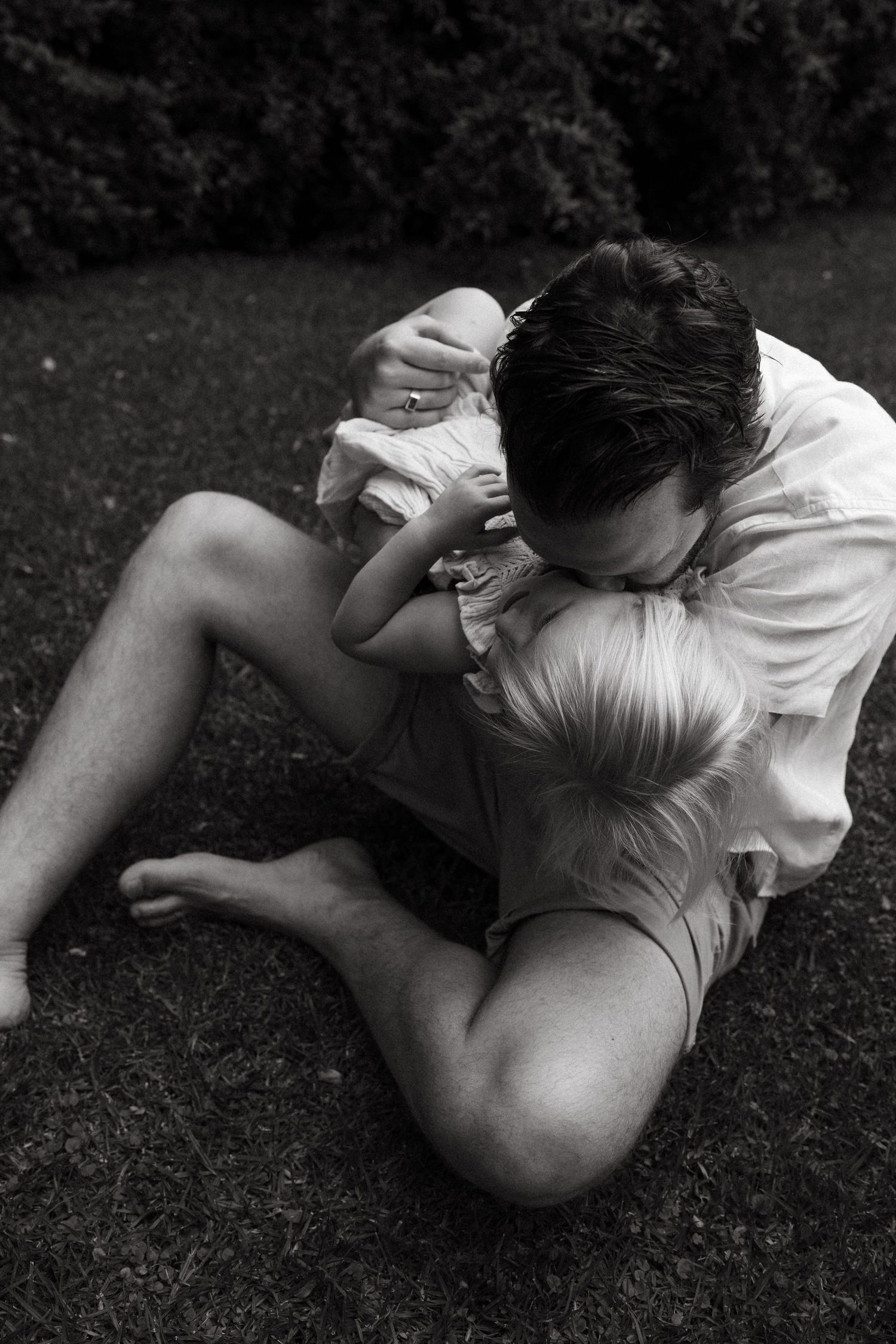 A black and white sequence showing intimate moments of connection on grass.