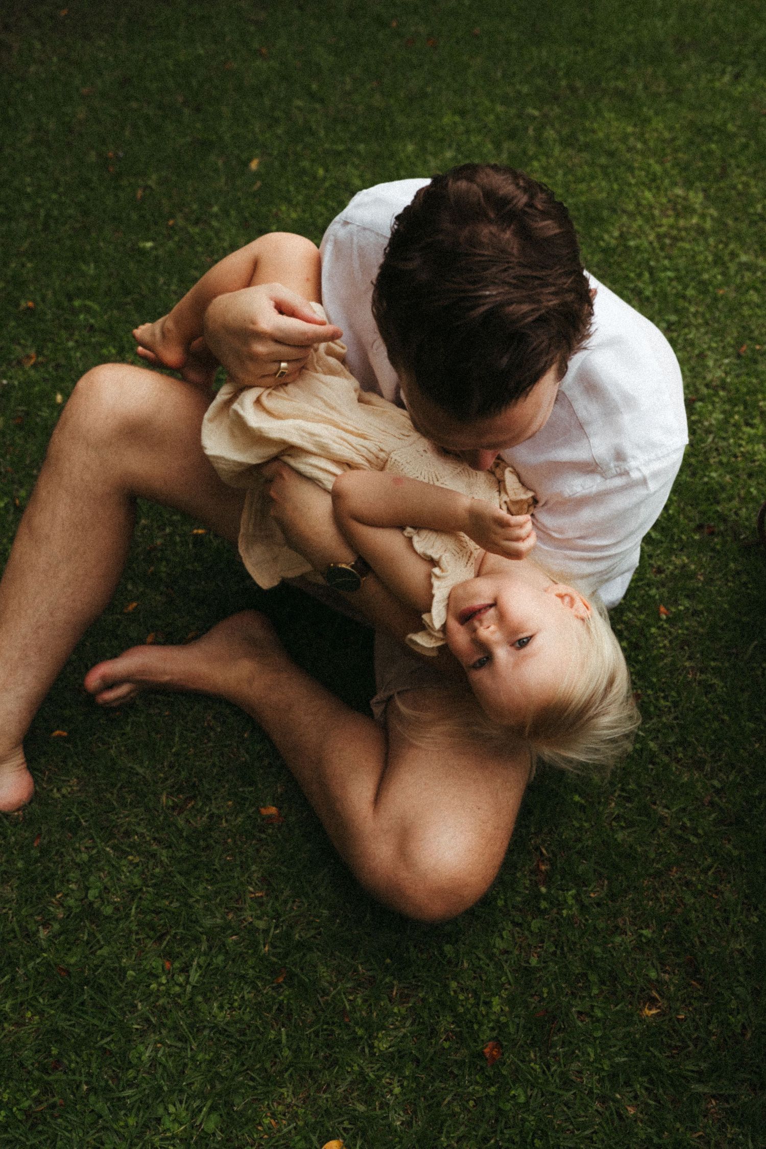 A series of candid moments between family members lying on grass.