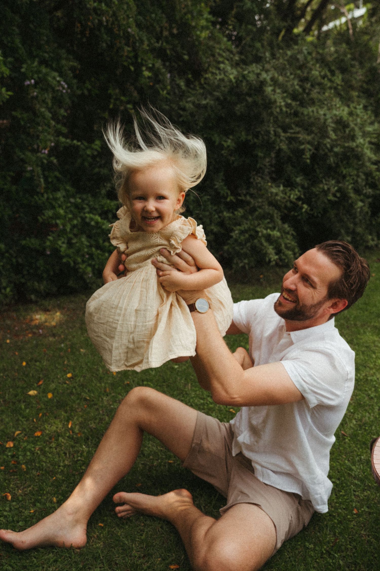 Joyful playtime moments captured between family members on a lawn.