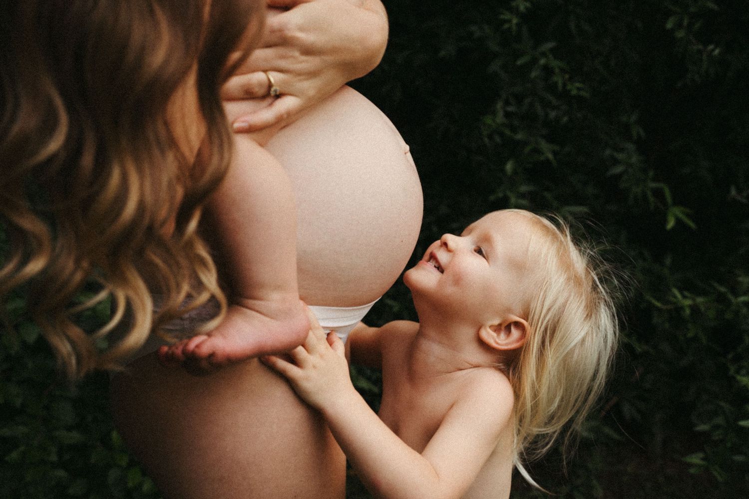 A tender moment between parent and child during a candid outdoor family photo session.