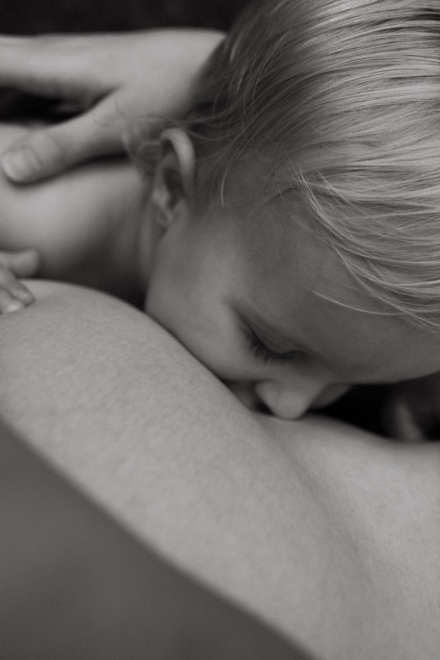 An intimate black and white close-up photo showing a gentle moment of connection.