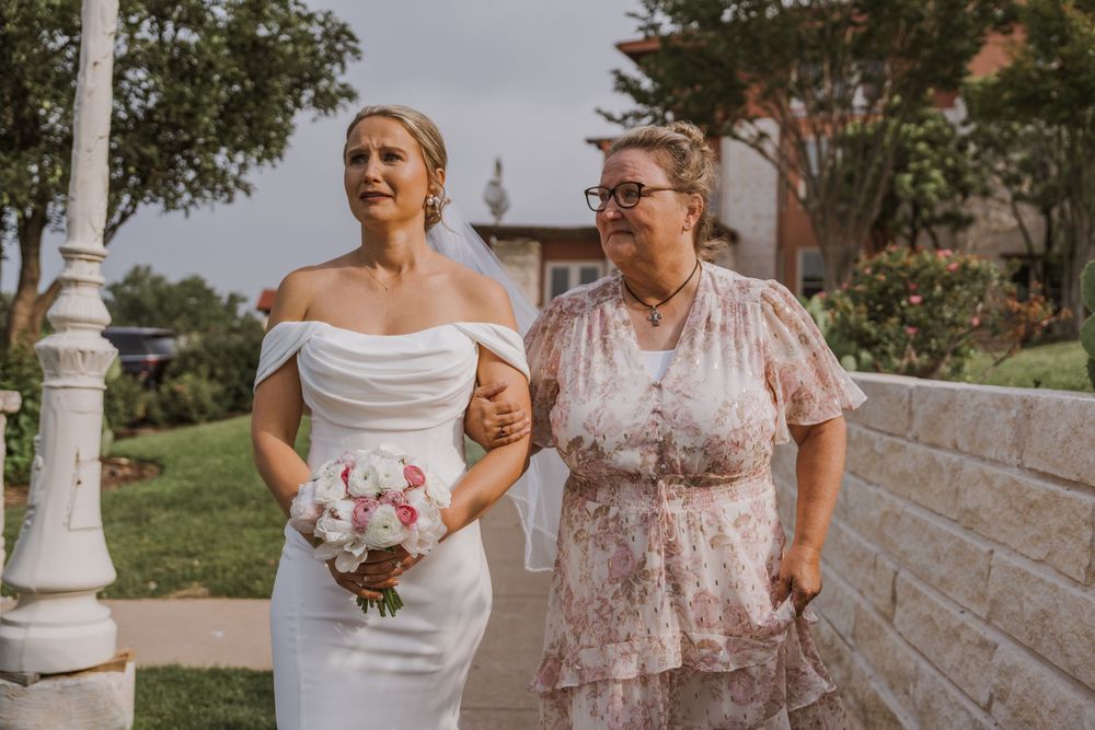 Wedding day scene with bouquet on stone-walled garden path.
