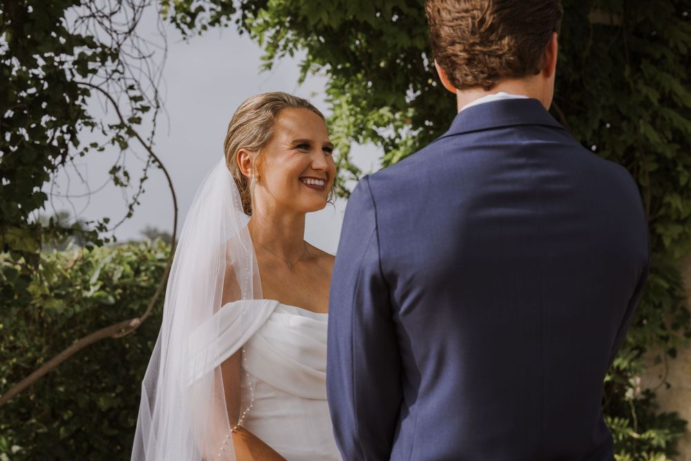 A candid moment between newlyweds sharing laughter during their outdoor photo session.