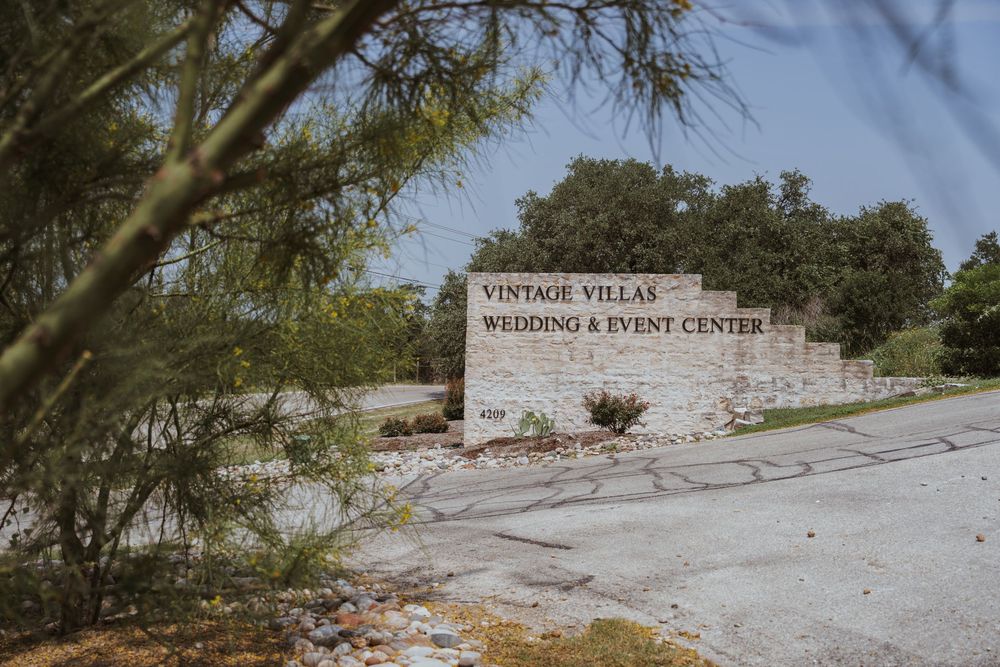 Vintage Villas Wedding & Event Center entrance sign with stone wall backdrop.