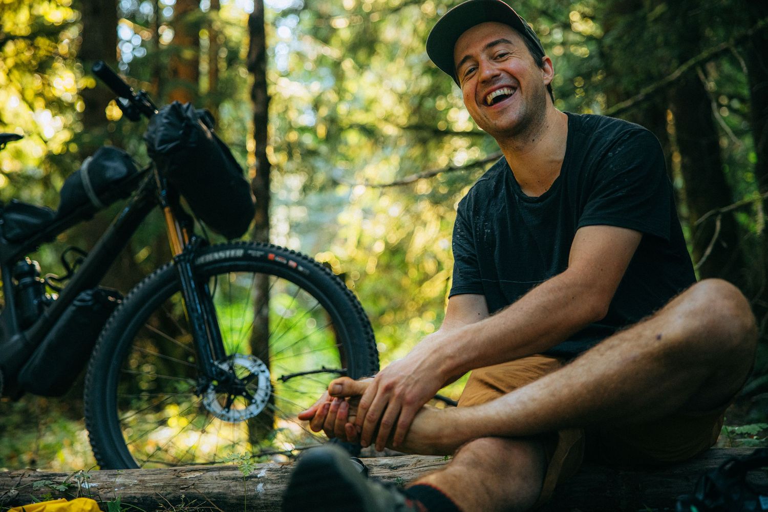 Mountain biker taking a break on a sunny trail in the forest.