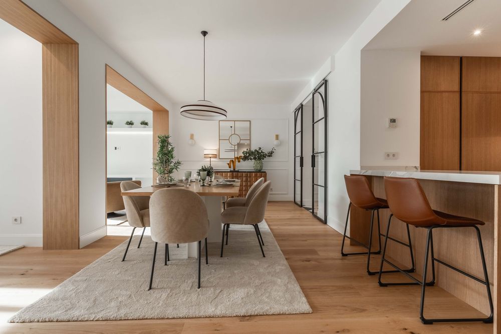 Comedor principal con barra de cocina y taburetes en espacio de concepto abierto