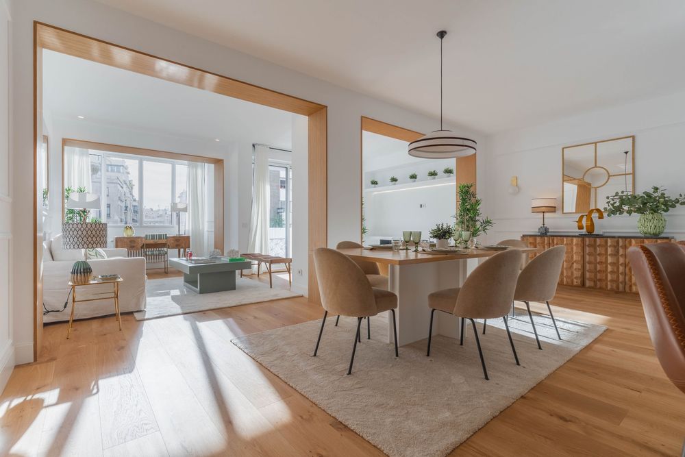 Salón comedor amplio con luz natural, mobiliario moderno y tonos cálidos