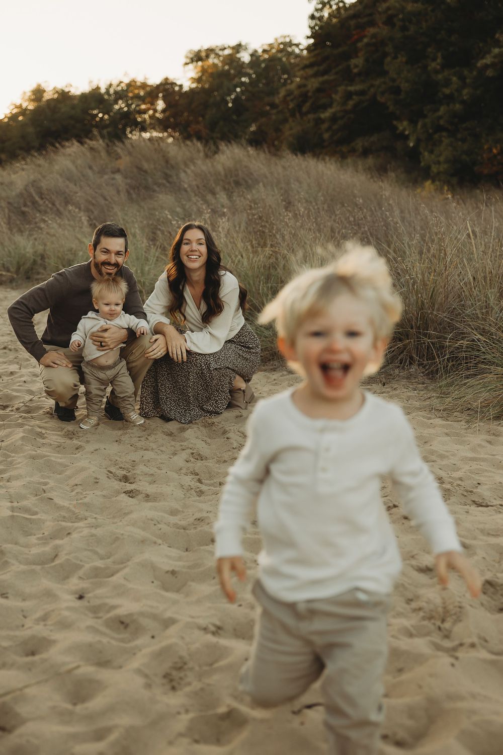 A joyful family photoshoot sequence on a sandy beach with natural lighting and candid expressions.