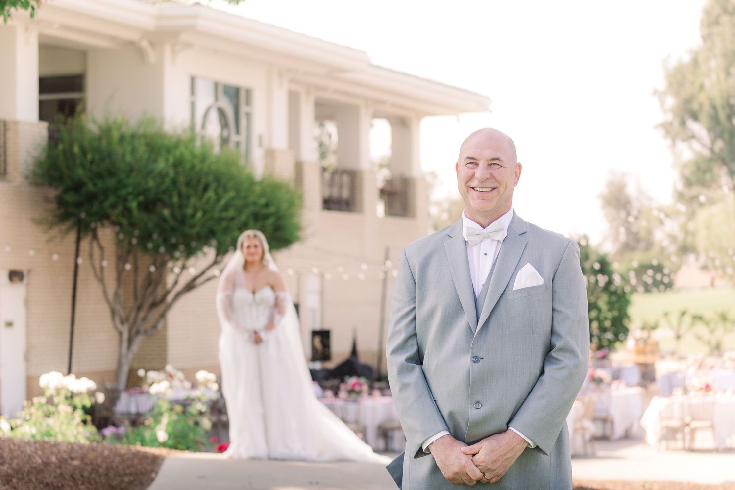 Joyful first look reaction during outdoor wedding at elegant venue.
