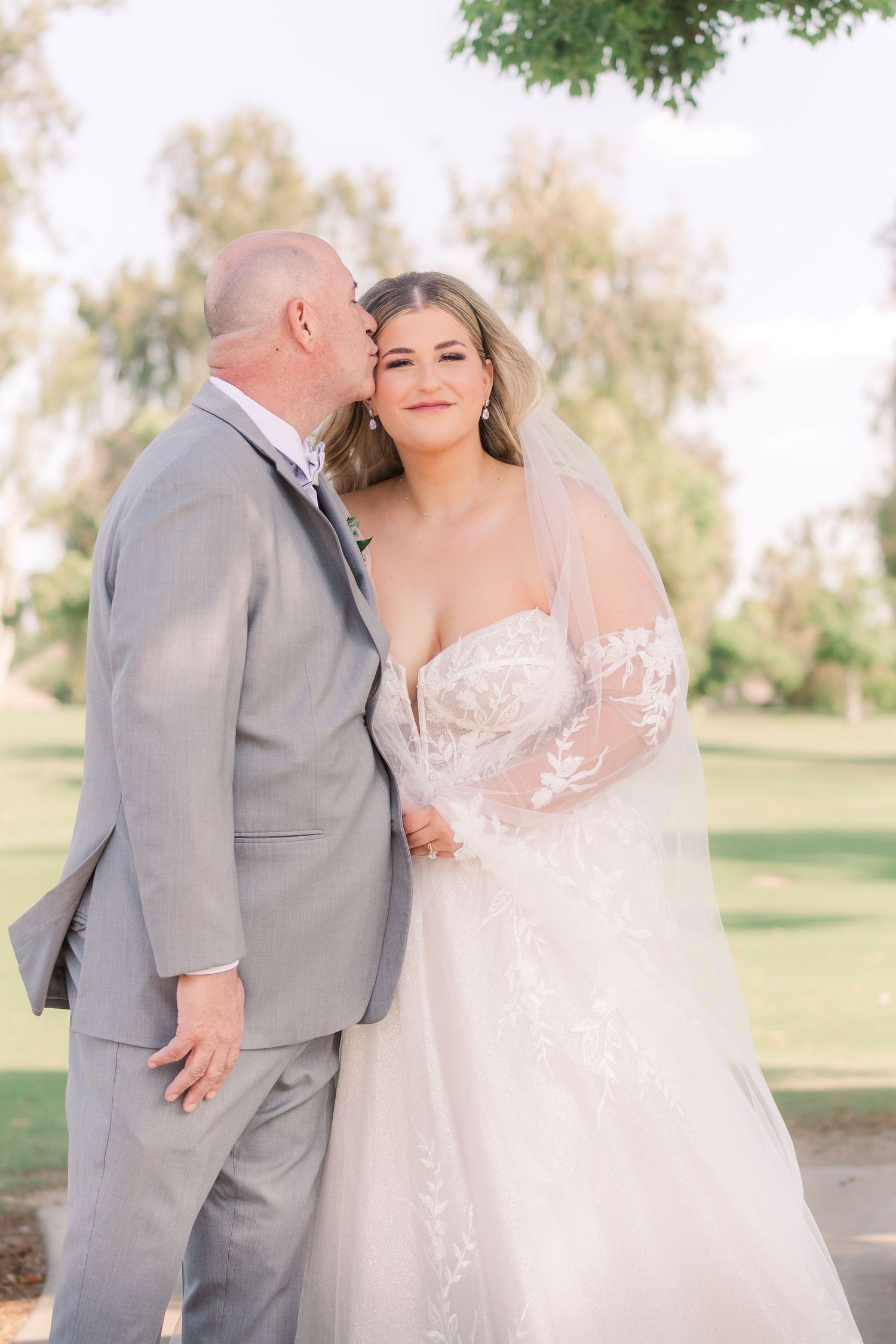 Tender moment shared between couple during outdoor wedding portraits.