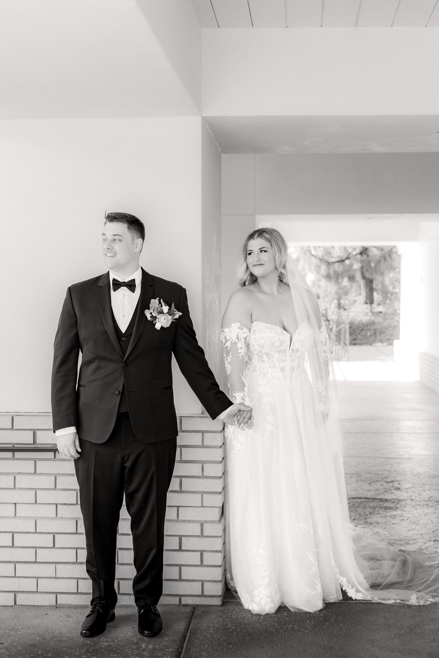 Classic black and white wedding portrait under covered walkway.