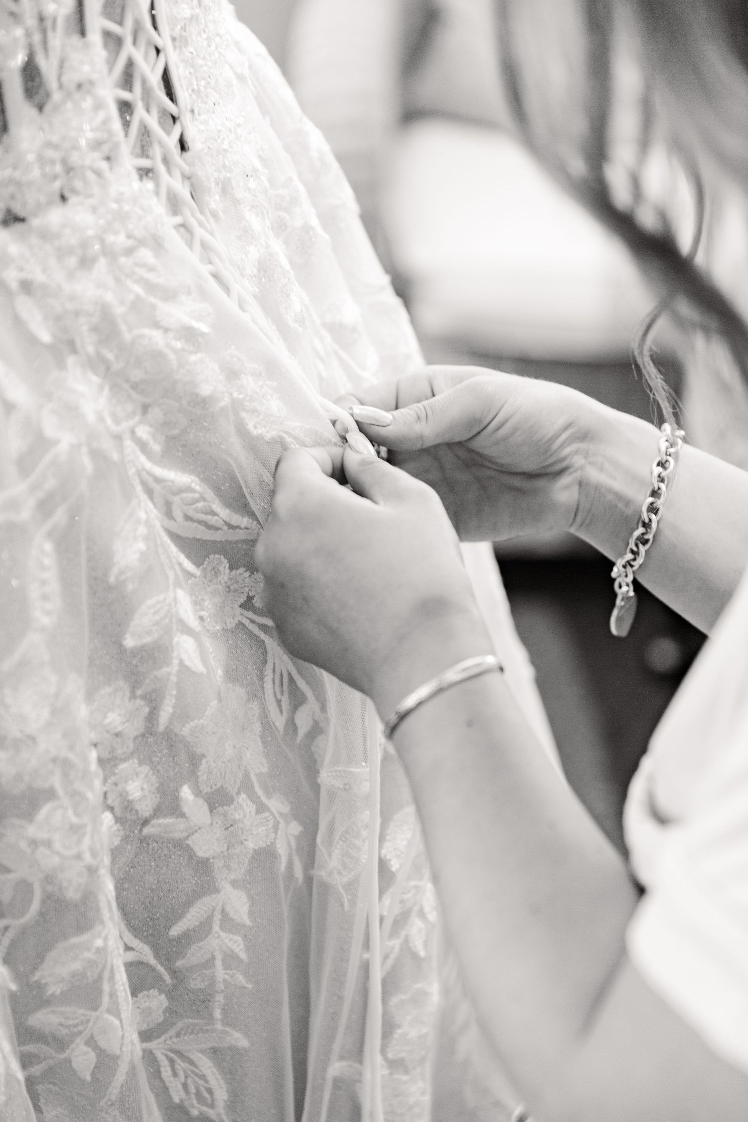 Delicate lace details of a wedding dress shown in black and white close-up shots.