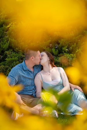 yellow flower bokeh with couple kissing in the center