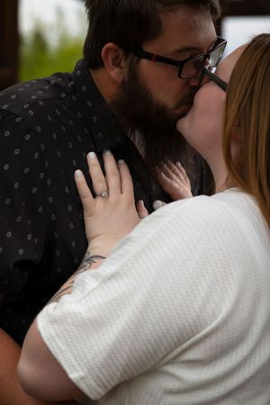 couple kissing, focus on ring