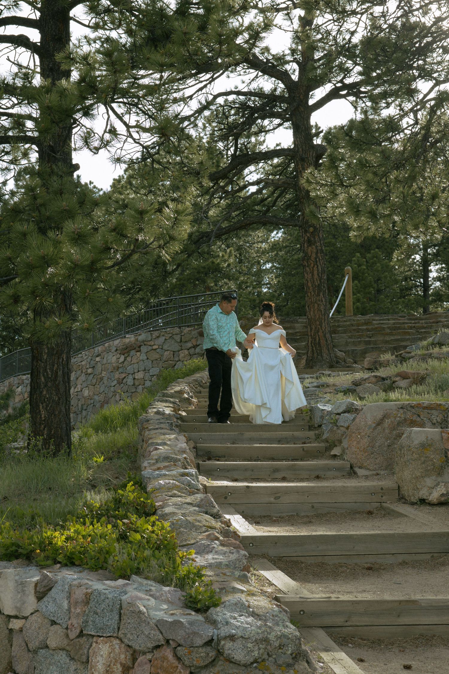 Bride making her entrance down the stone steps at Sunrise Amphitheater during an intimate wedding ceremony in Boulder.