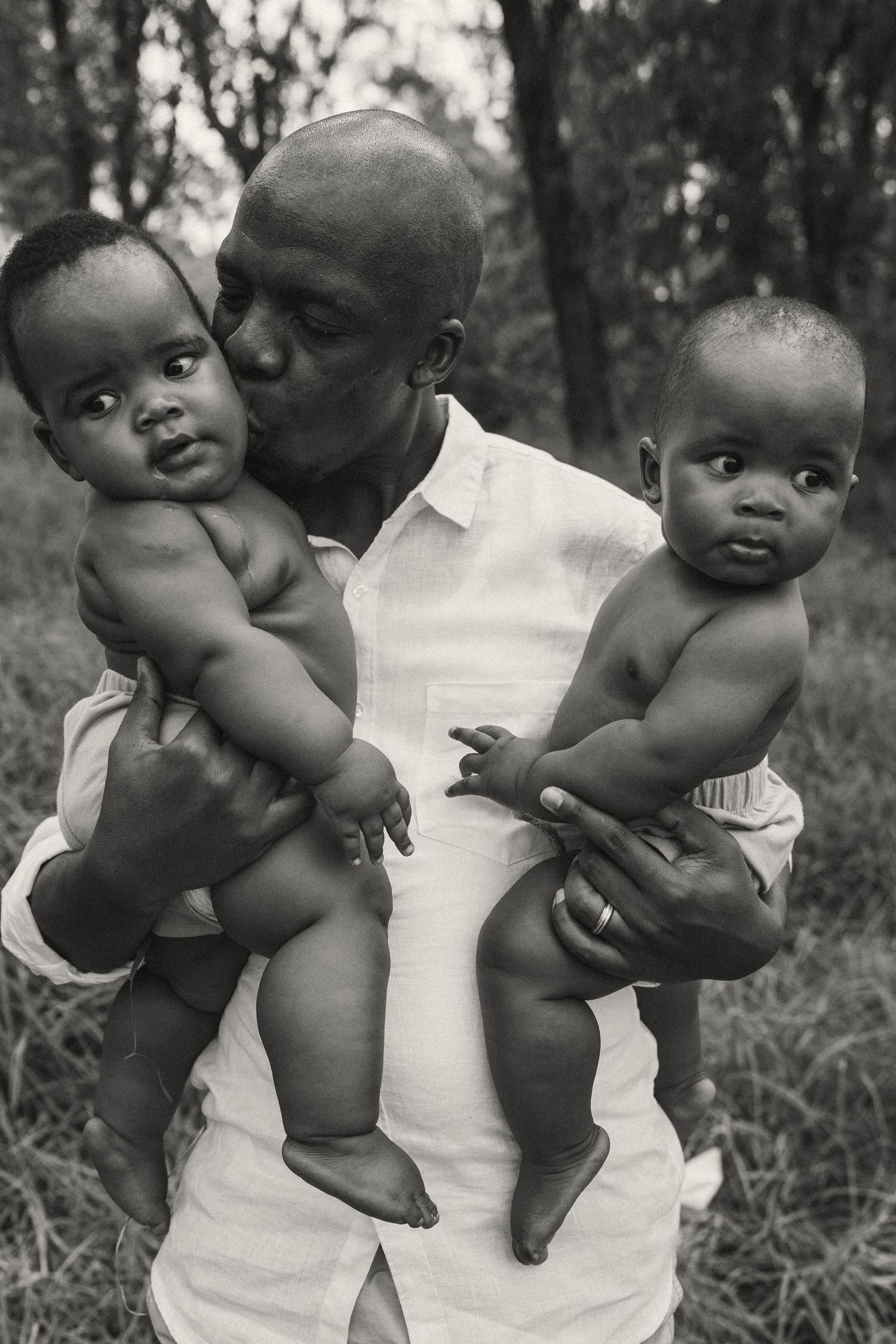A series of black and white photos showing a baby being playfully held up in the air.