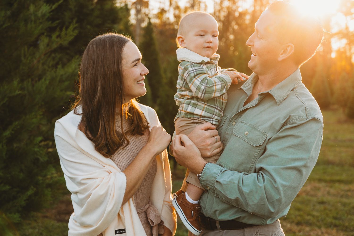 Family shares joyful moment together during golden hour outdoor photoshoot.