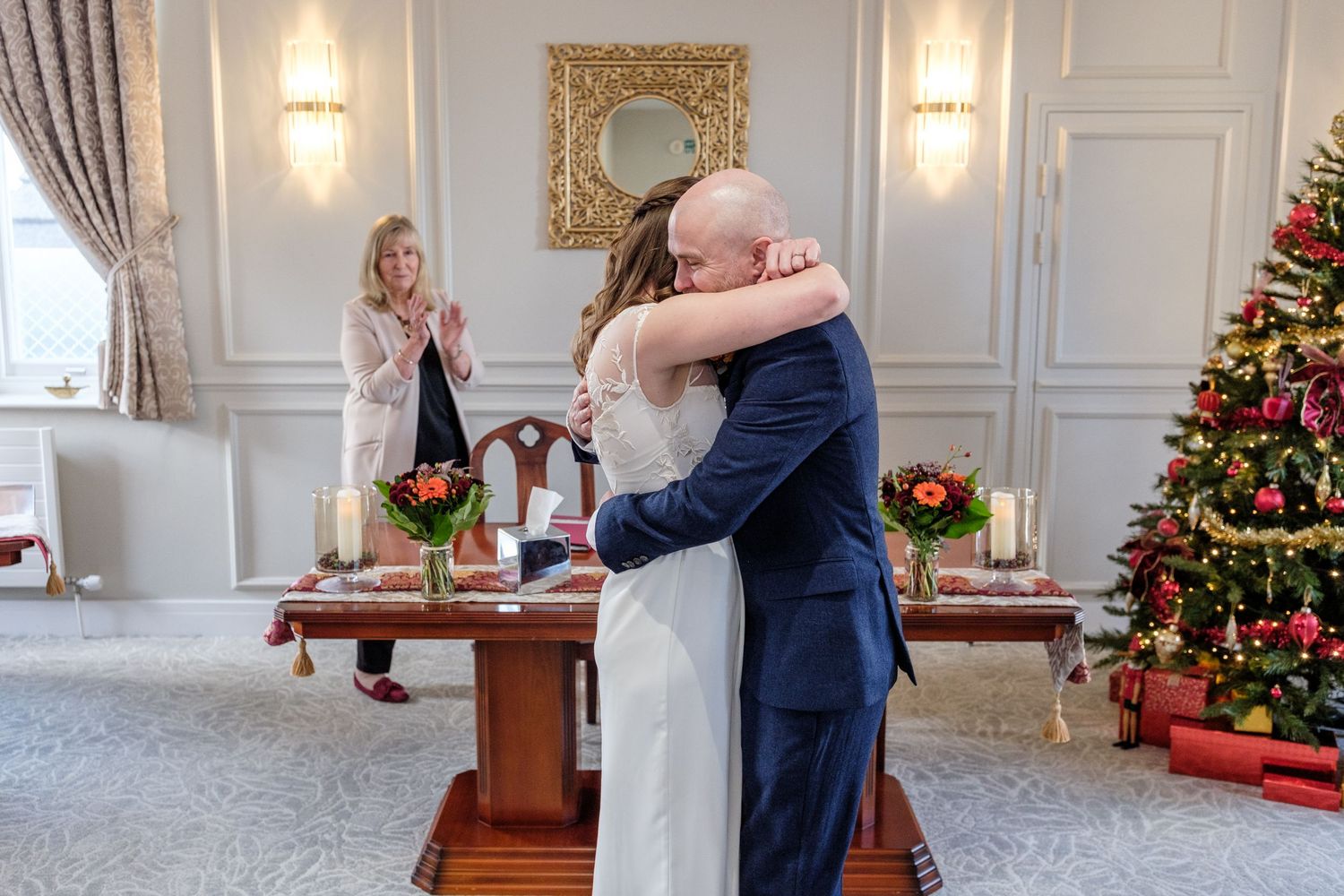 A sequence of photos showing a couple celebrating their wedding ceremony in an elegant room with white walls and chandeliers.