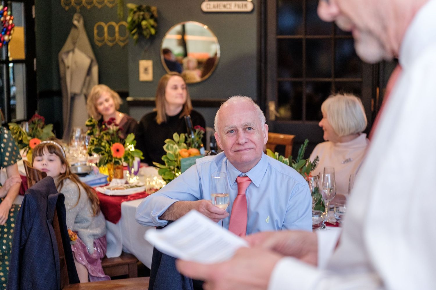 Guests seated at tables enjoying a meal during a celebratory dinner event in a restaurant setting.