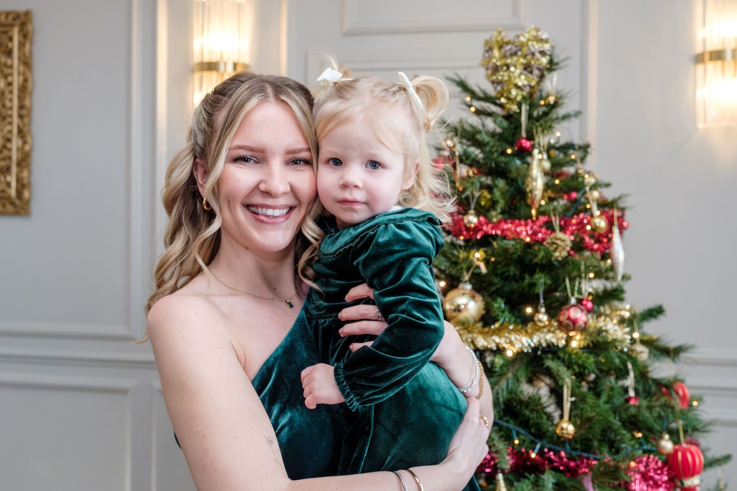 Christmas family photos with decorated tree and white wall background.