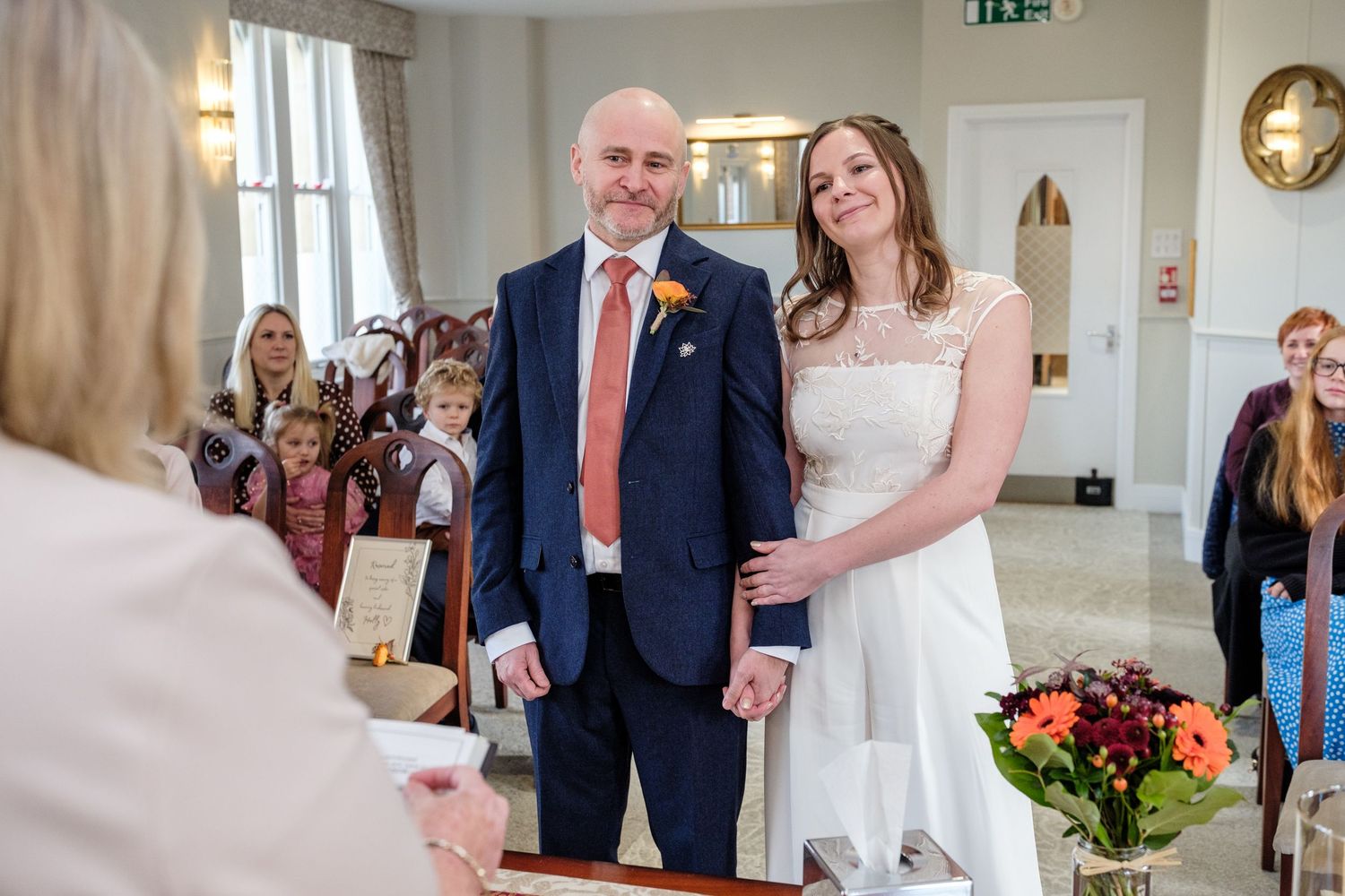 A wedding ceremony collage showing various moments from the signing of marriage documents in an elegant indoor venue.