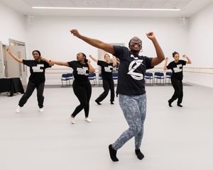 Dance class participants practicing choreography in a bright studio space.