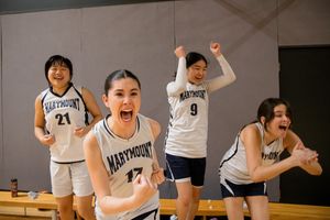 Basketball players celebrating and cheering together in a gymnasium.