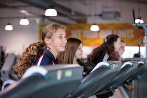 Students engaged in various sports activities and competitions in a gymnasium setting.