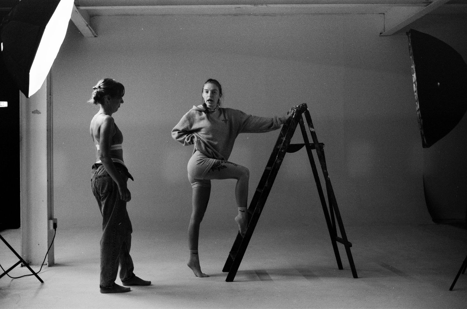 Behind the scenes photo of a professional photo studio setup with lighting equipment and people working on set.