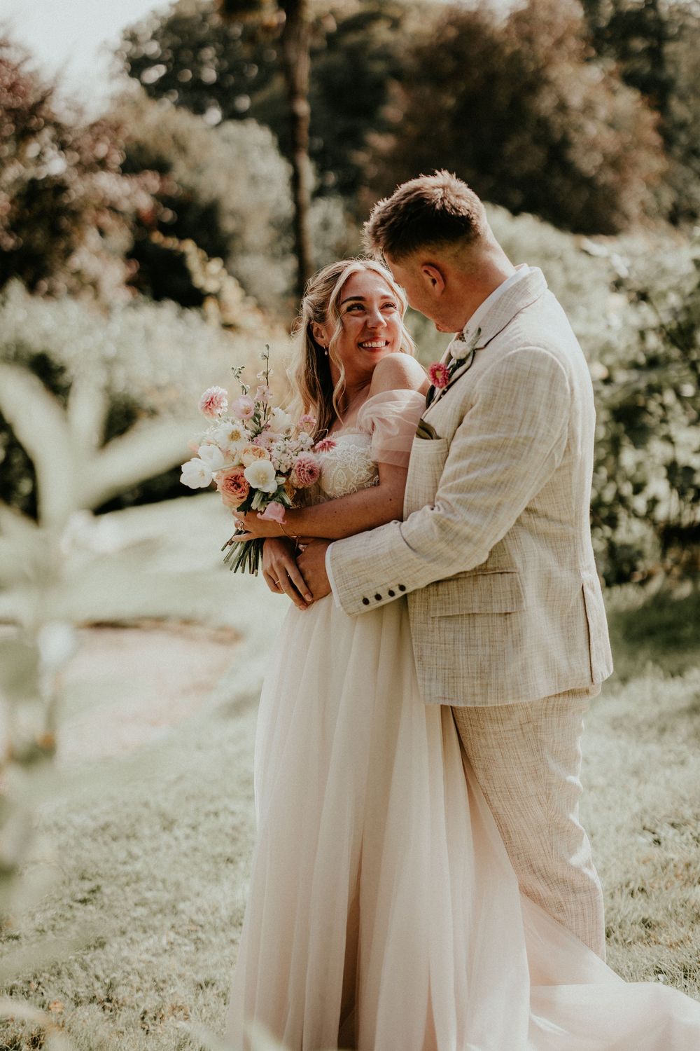 Romantic outdoor wedding photoshoot sequence showing couple embracing in soft natural lighting and garden setting. Cornwall wedding photo