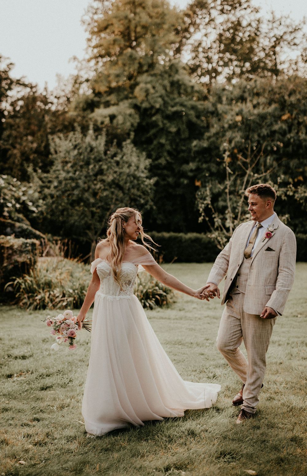 A couple dances together on a grassy lawn during a romantic outdoor wedding photo session. Cornwall wedding photographer