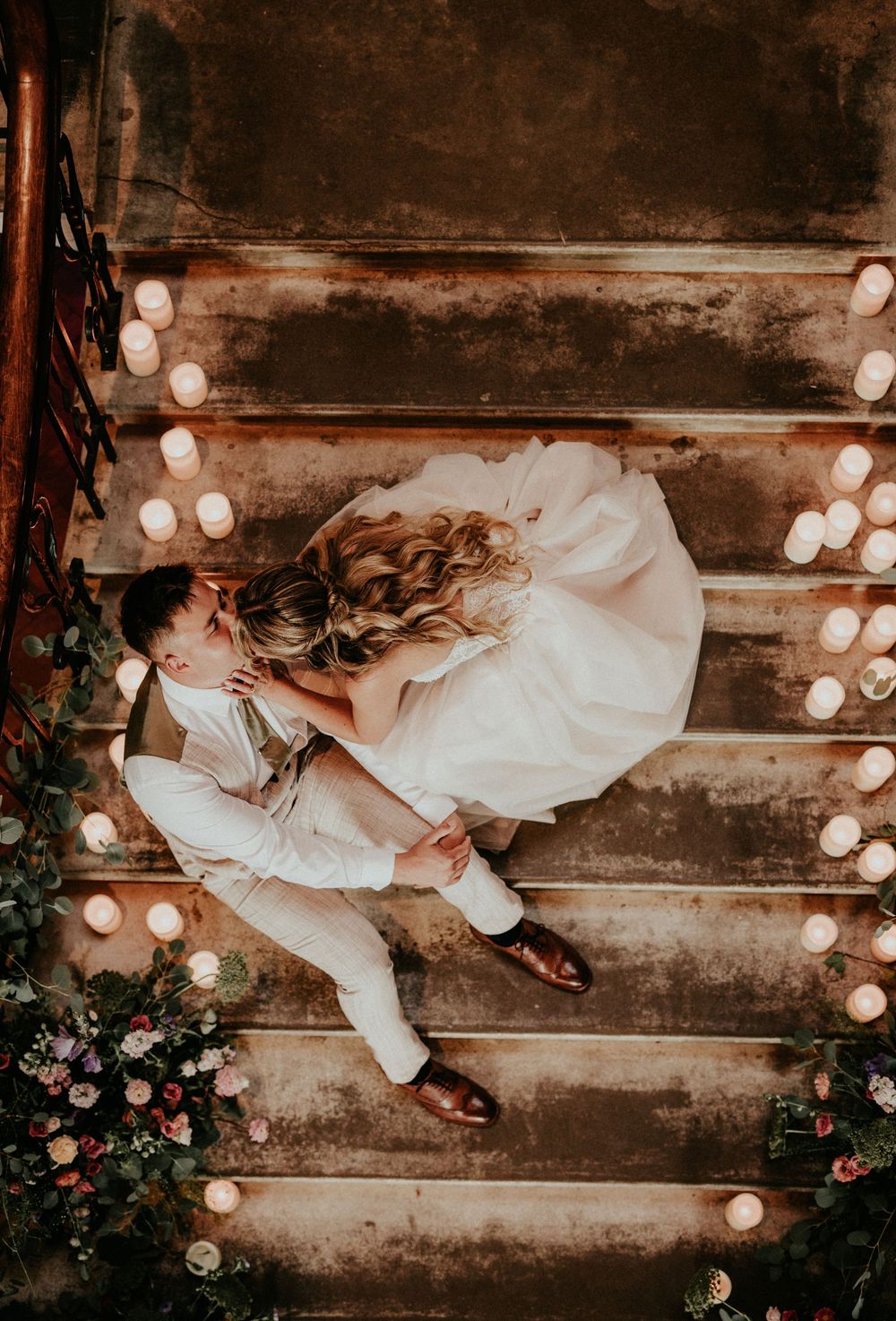 A sequence of artistic wedding photos showing a person in white lying on rustic wooden steps decorated with string lights.