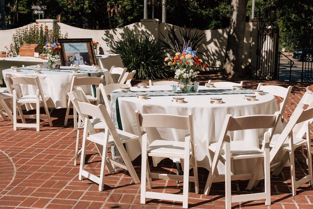 Detailed shot of the homemade jam wedding favors placed next to the simple, beautiful DIY table decorations in the courtyard.