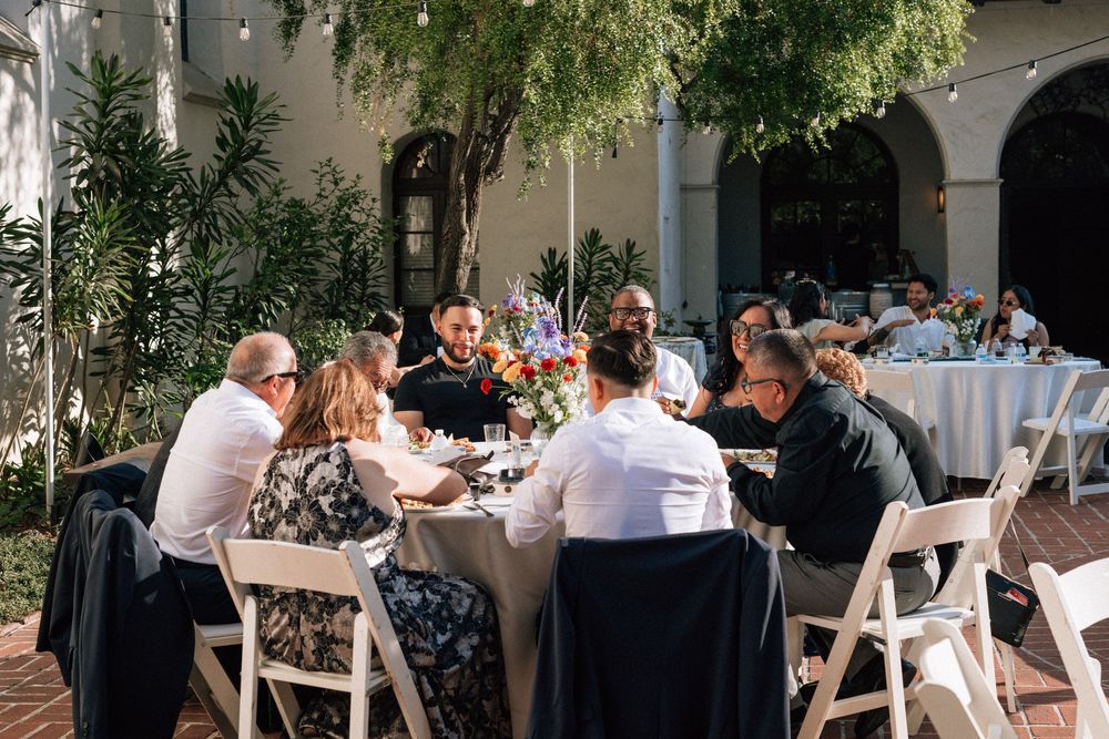 A wide-view digital image of guests seated at dinner tables, enjoying the casual atmosphere of the non-traditional Santa Barbara wedding.