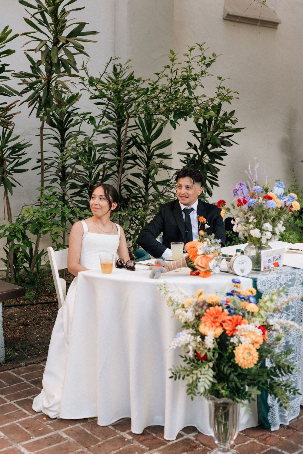 A Santa Barbara wedding photographer captures a candid moment of the bride and groom listening to their wedding toasts at Unitarian Society.