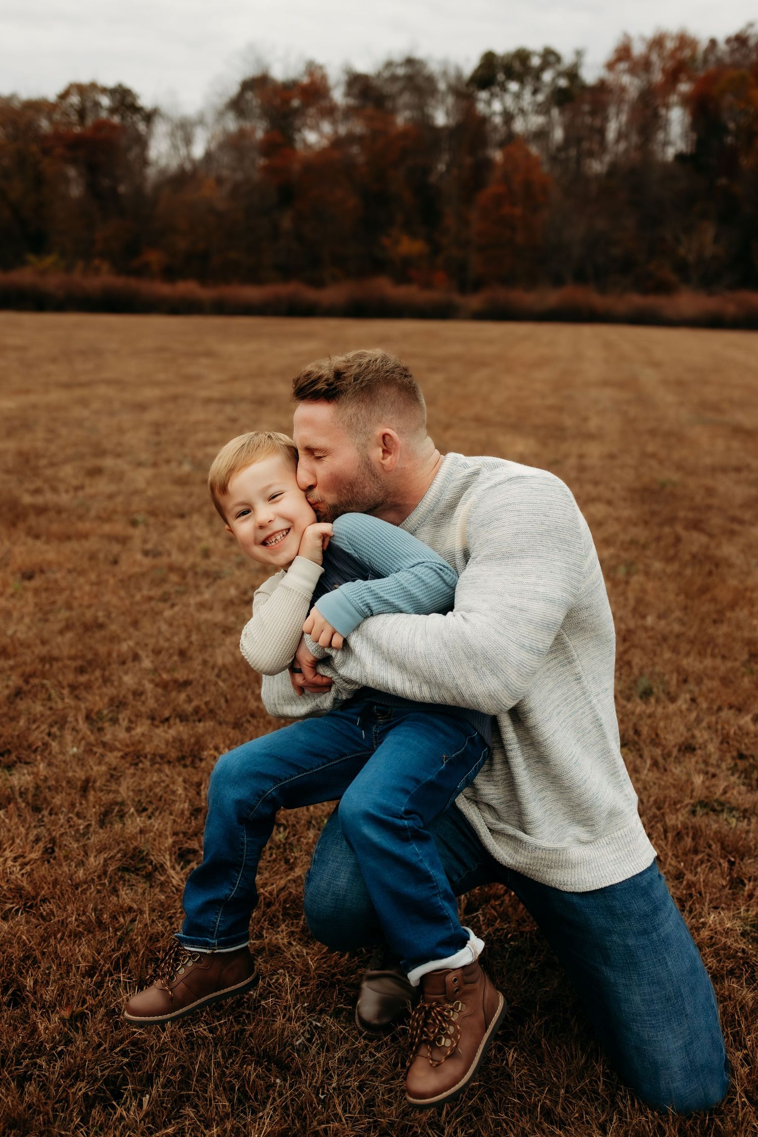 A heartwarming moment between parent and child playing together in an autumn field at sunset.