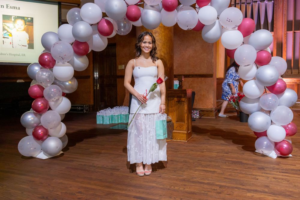 Balloon garland with pink and white colors frames an indoor celebration space.