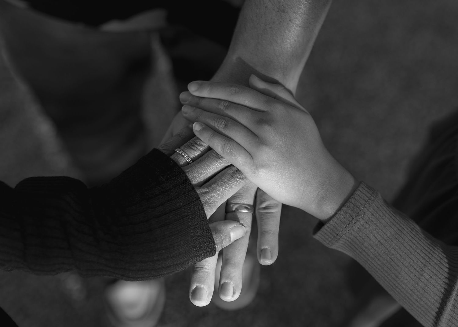Black and white photograph showing hands joined together in a tender moment.