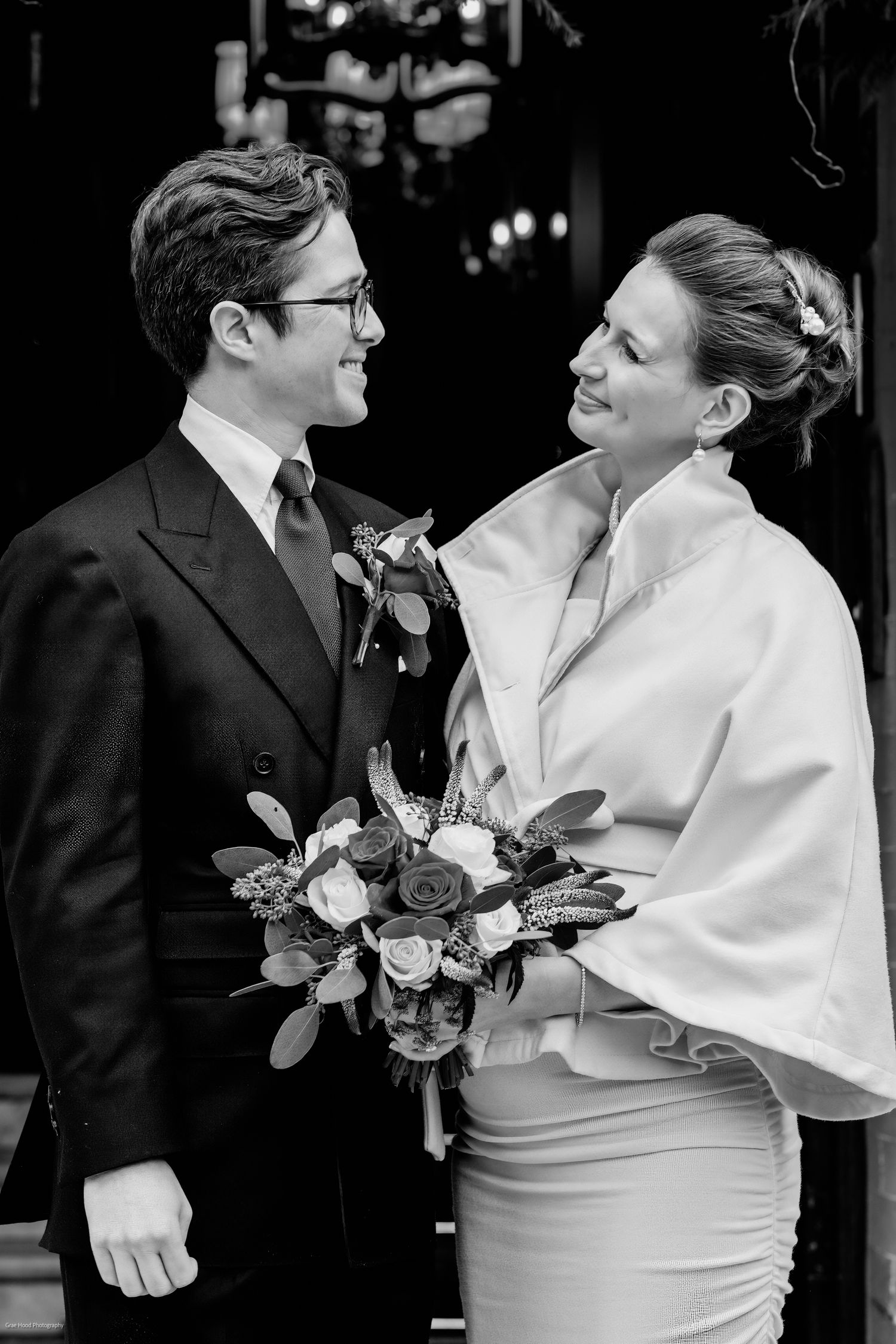 A romantic black and white wedding photo series showing tender moments between newlyweds with roses.