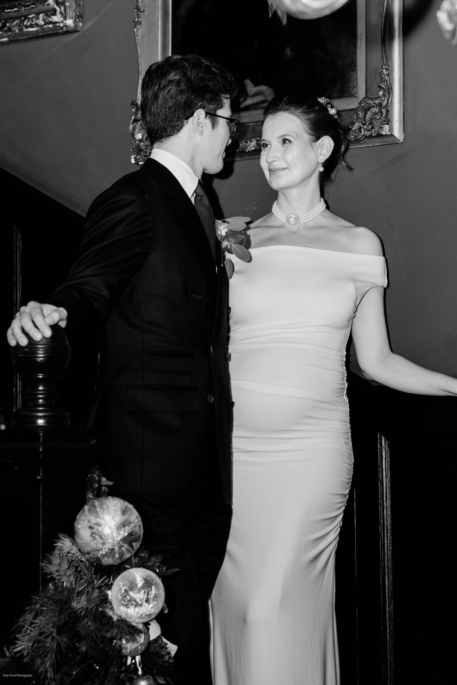 Intimate black and white wedding portraits showing couple's tender interactions in indoor setting.