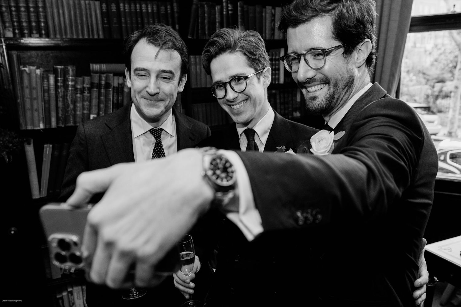 A series of black and white photos showing people laughing and smiling together in candid moments.