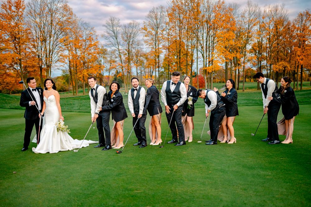 Wedding party poses in creative sequence on vibrant green lawn with autumn trees displaying orange foliage in background.