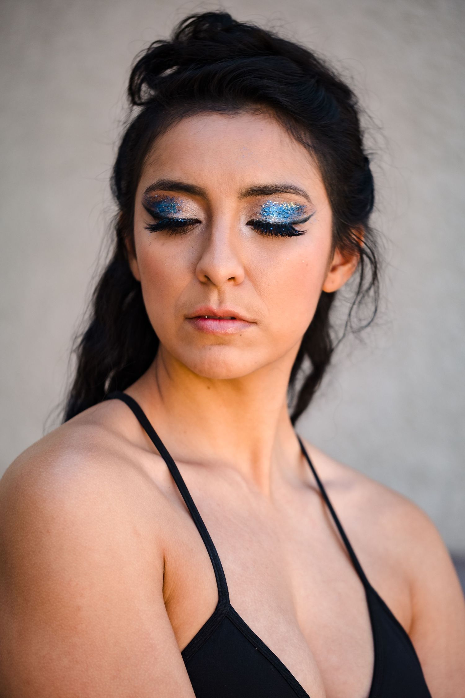 A series of close-up beauty shots showing dramatic eye makeup and black strappy top against a neutral background. Vacaville fashion show