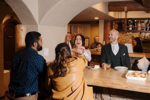 Cozy restaurant interior with arched ceiling and warm lighting showing guests seated at bar counter.