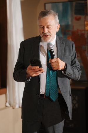A person in a gray suit and teal tie looks at their mobile phone while holding a coffee cup in a sequence of photos.